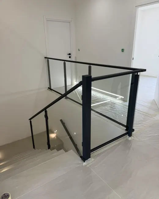 garde-corps intérieur verre transparent et cadre aluminium noir autour d’une trémie d’escalier