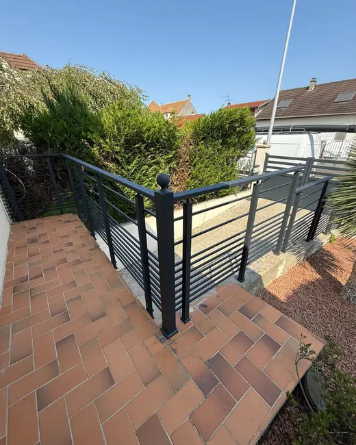 rambarde extérieure à lisses en aluminium anthracite le long de marches en brique