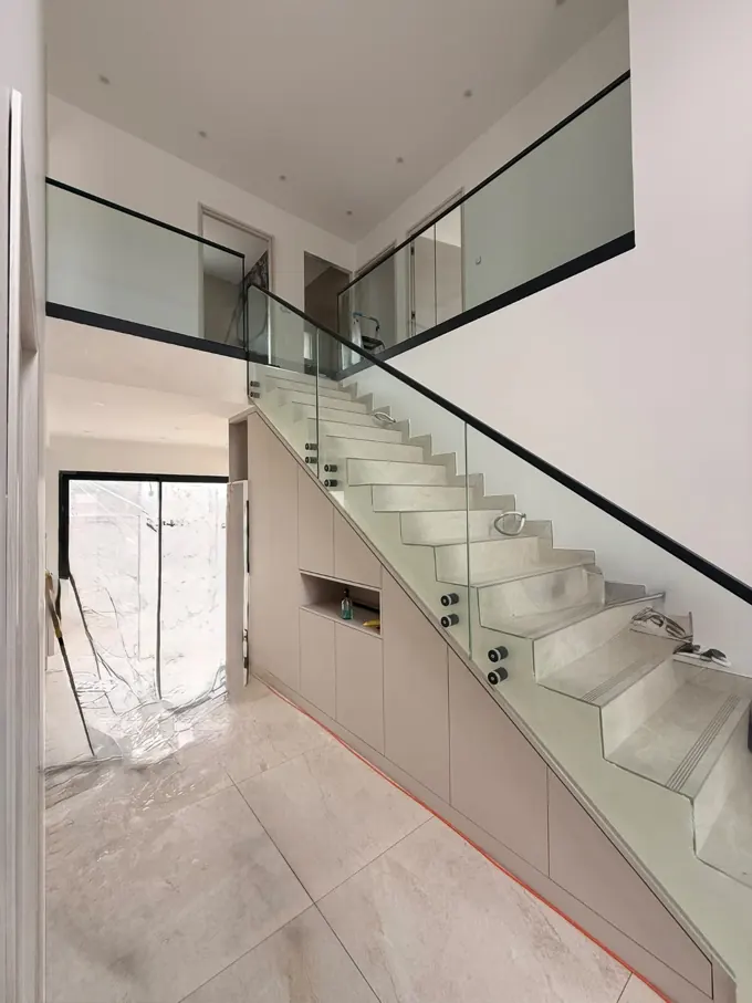 Escalier intérieur en verre et profils noirs, sur deux niveaux