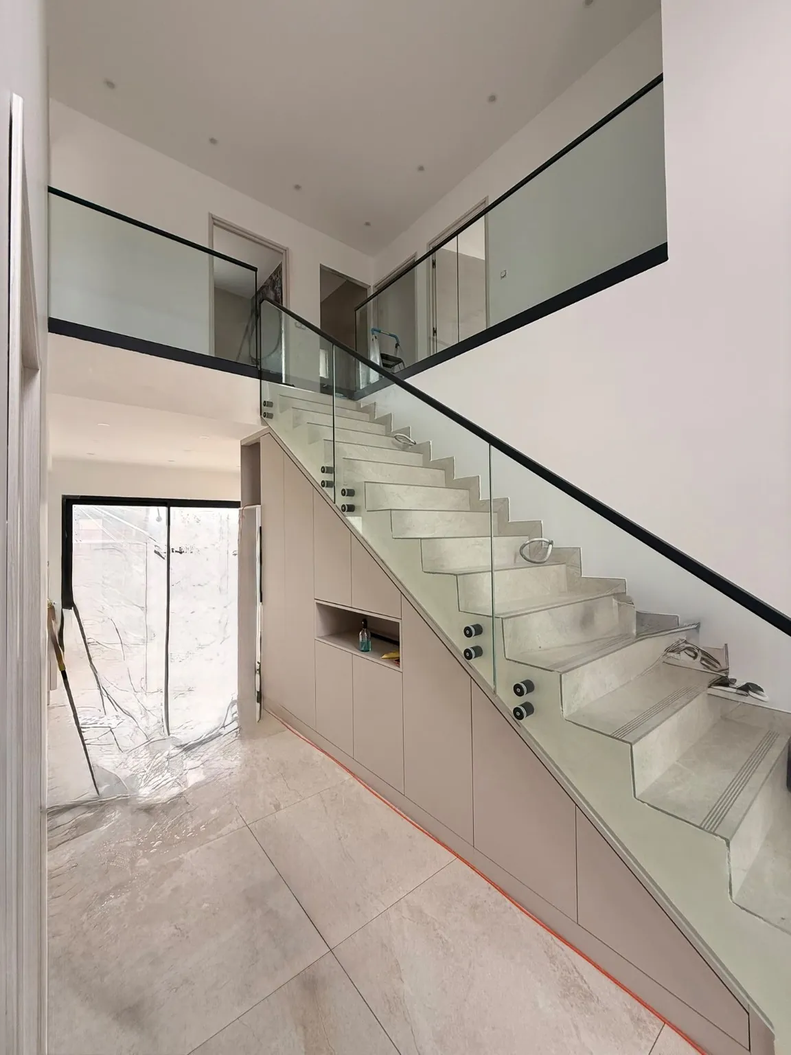 Escalier intérieur en verre et profils noirs, sur deux niveaux