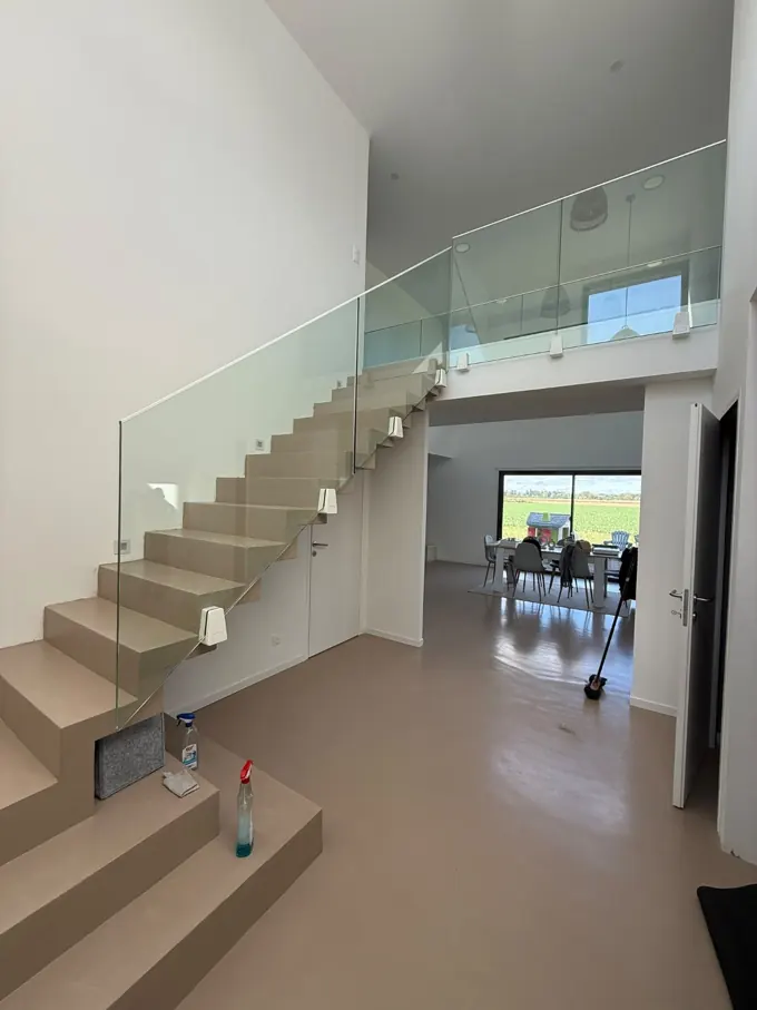 Escalier vitré installé dans une maison avec mur de pierre apparente